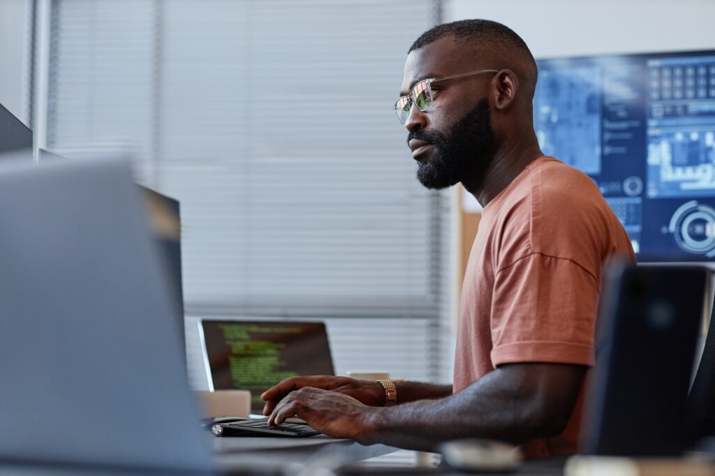 Man reviewing analytics on dual monitors, representing SaaS teams that hire data engineers to rebuild reporting pipelines.