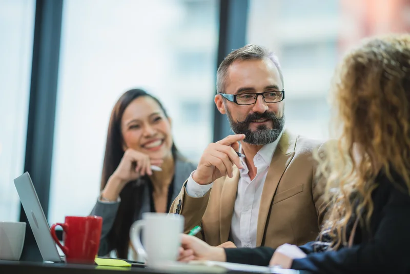 Business professionals discussing hiring needs in a meeting, representing sector support and candidate placement in London IT recruitment.